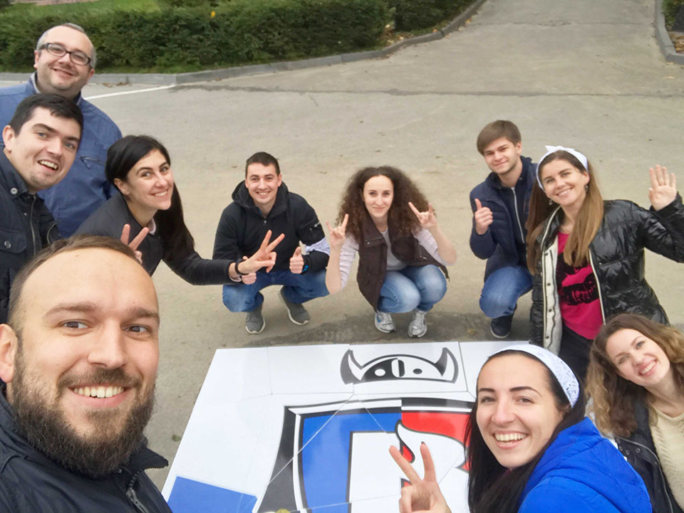 team celebrating Stfalcon.com anniversary with a large puzzle outdoors