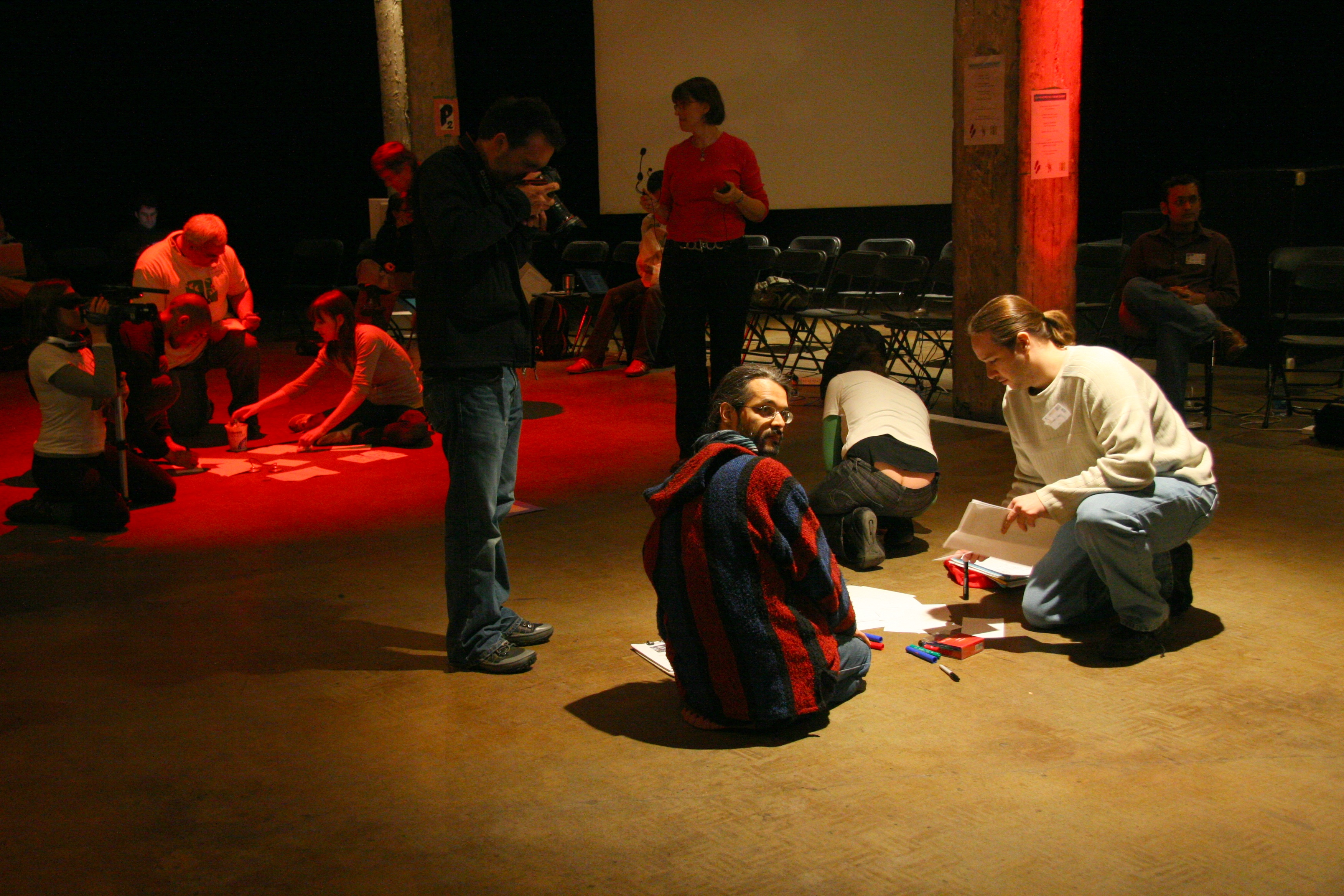 participants collaborating in a workshop setting with papers and tools