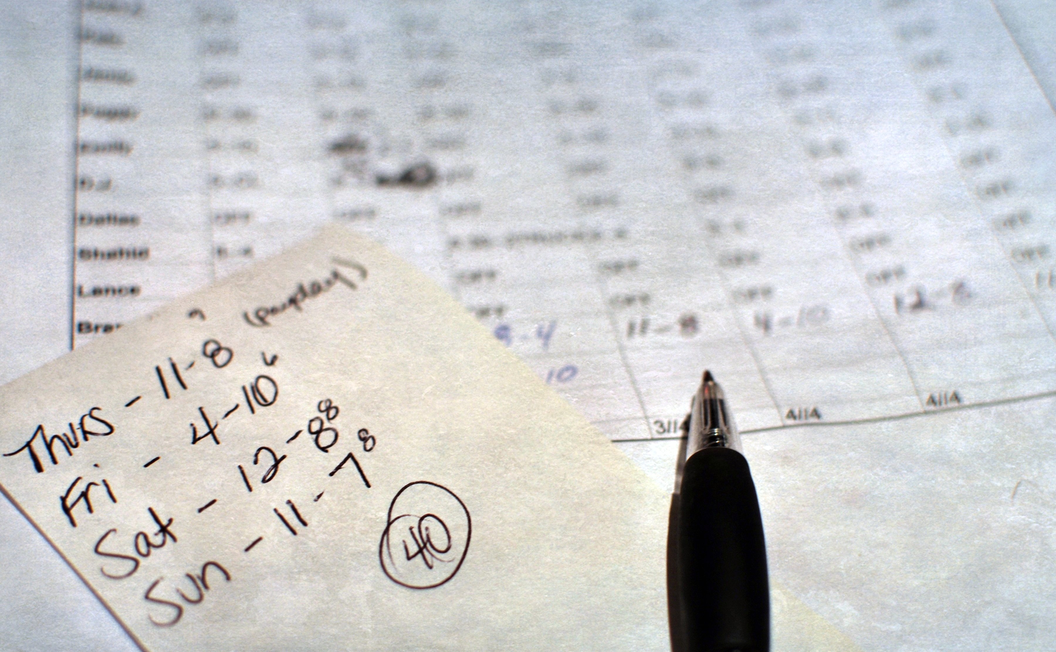 employee schedule with handwritten notes and a pen