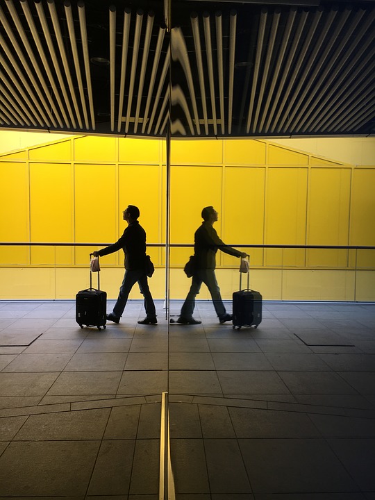 Traveler with luggage walking in an airport corridor